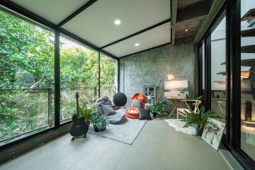 Bright and modern living room with large windows and greenery view