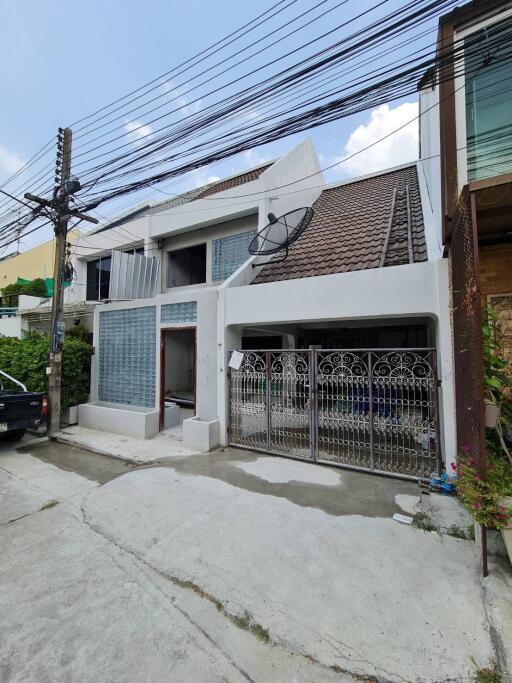 Two-story house exterior with gated entrance