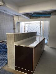 Contemporary kitchen under renovation with a breakfast bar and tiled walls