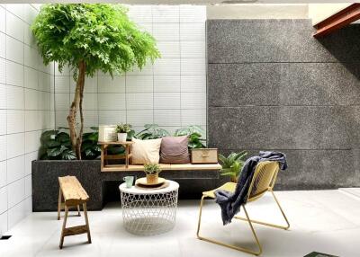 Cozy modern balcony with seating area and potted plants