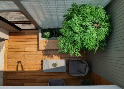 Aerial view of a cozy balcony with wooden flooring and greenery