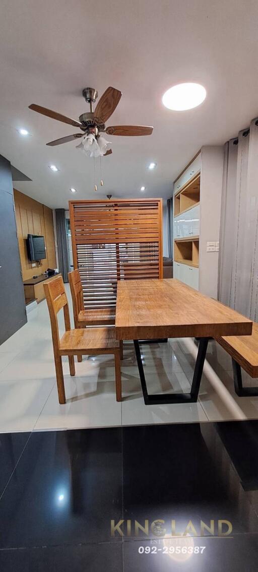 Modern dining area with wooden furniture and ceiling fan