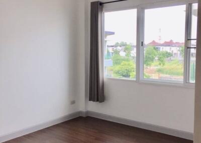 Empty bedroom with hardwood floors and large window