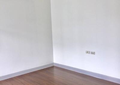 Empty bedroom with hardwood floors and air conditioning unit