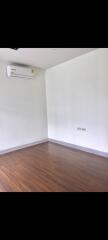 Empty bedroom with hardwood floors and air conditioning unit