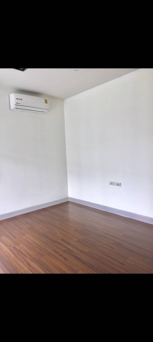 Empty bedroom with hardwood floors and air conditioning unit