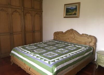 Bedroom with large bed and wooden wardrobes