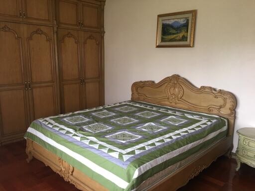 Bedroom with large bed and wooden wardrobes