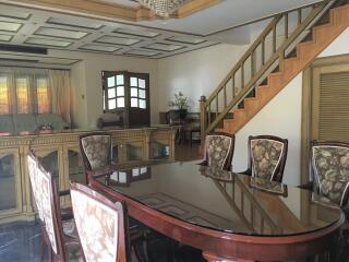 Spacious dining area with a large wooden table and upholstered chairs