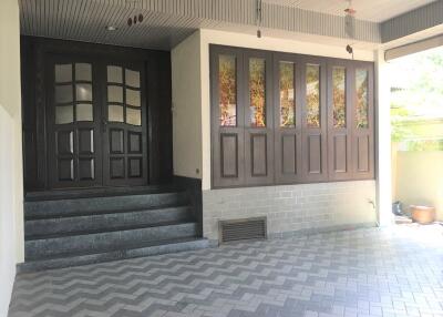 Main entrance with large dark wood doors and tiled steps