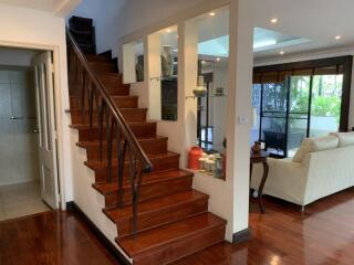 Living room with staircase and open space to a seating area