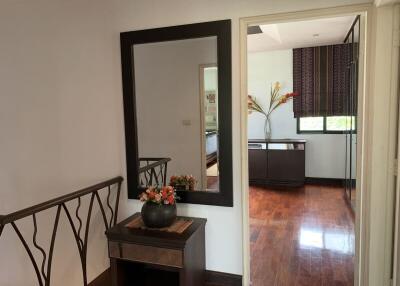 Hallway with mirror and table, view into another room