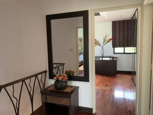 Hallway with mirror and table, view into another room