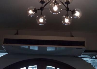 Modern ceiling light fixture with an air conditioning unit and an arched window