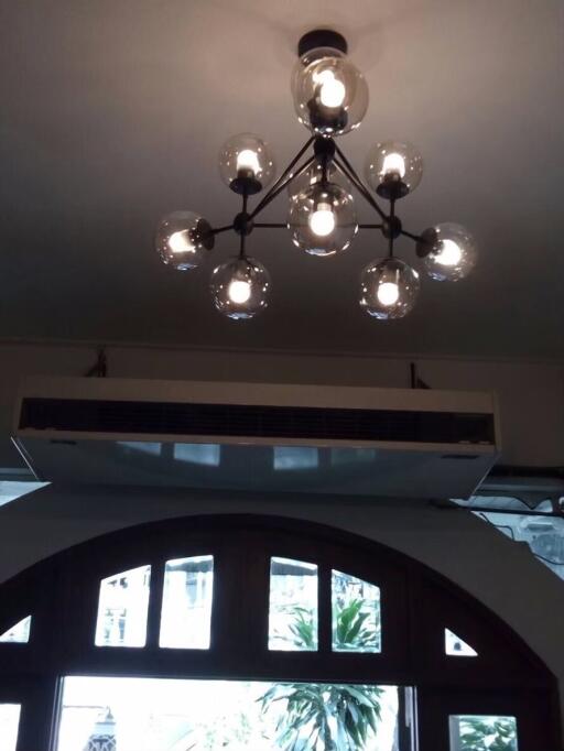 Modern ceiling light fixture with an air conditioning unit and an arched window