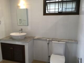 Modern bathroom with sink, mirror, and toilet