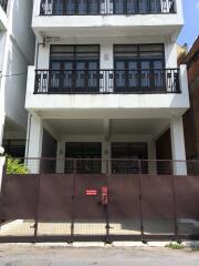 Front view of a residential building with balconies and gated entrance