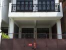 Front view of a residential building with balconies and gated entrance