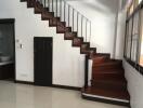 Modern wooden staircase with under-stairs storage and nearby sink area