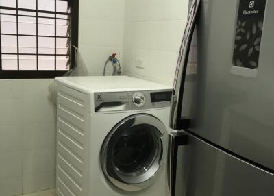 Laundry room with washing machine and refrigerator