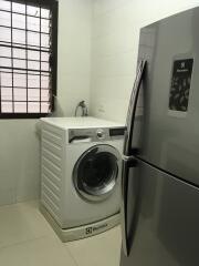 Laundry room with washing machine and refrigerator