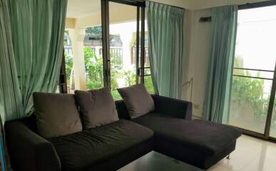 Living room with large windows and green curtains