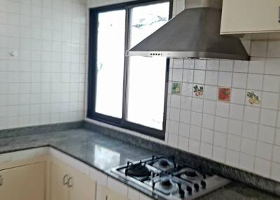 Kitchen with cabinets, granite countertop, window and gas stove