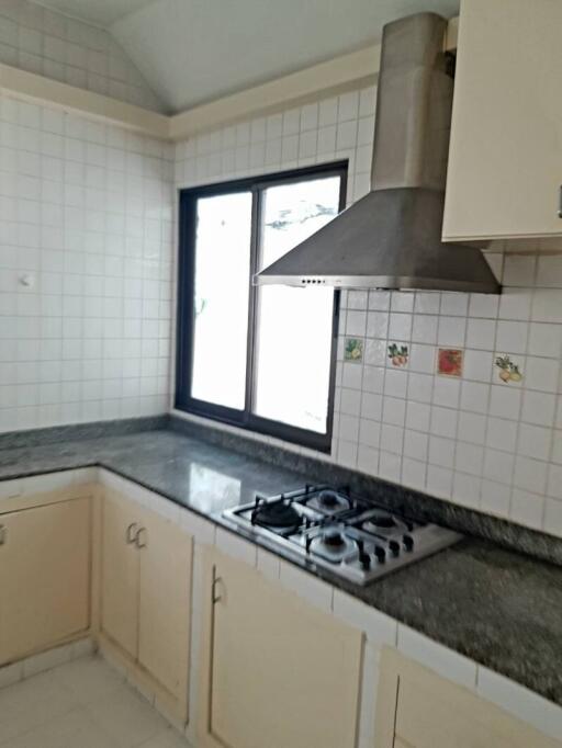 Kitchen with cabinets, granite countertop, window and gas stove