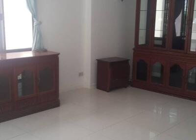 Living room with large window, air conditioner, and wooden furniture