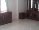 Living room with large window, air conditioner, and wooden furniture