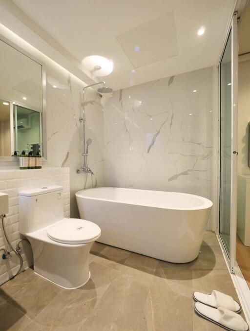 Modern bathroom with a bathtub, toilet, and shower