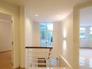 Well-lit hallway with stairway and open rooms