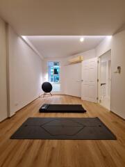 Minimalist bedroom with yoga mats and exercise equipment