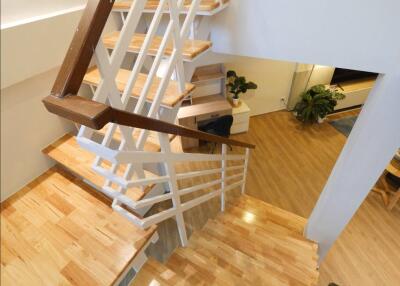 Staircase with wooden steps and white railings in a modern home