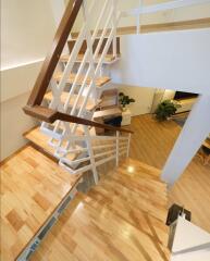 Staircase with wooden steps and white railings in a modern home