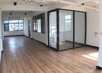 Spacious office area with large windows and wooden flooring