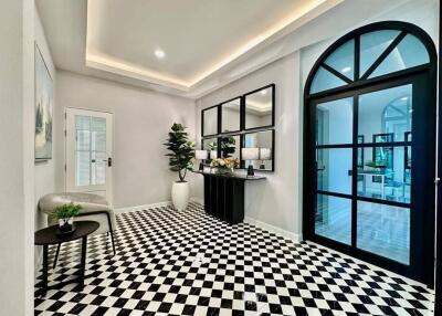 Elegant foyer with checkered flooring and modern decor