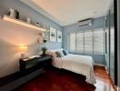 Modern bedroom with blue walls and wooden flooring