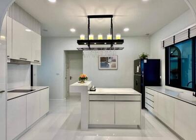 Modern kitchen with island, pendant lighting, and white cabinetry