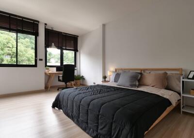 Modern bedroom with large windows and a wooden bed