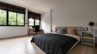 Modern bedroom with large windows and a wooden bed