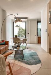 Modern living room with glass table, stylish rug, and adjacent dining area.