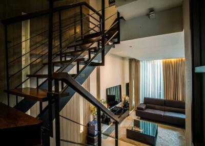 Modern living room with staircase and large window