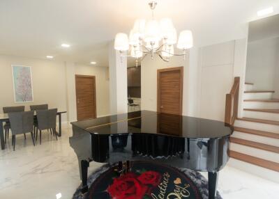 Main living space with grand piano and dining area