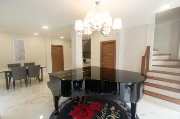 Main living space with grand piano and dining area