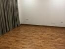 Empty living room with wooden floor and air conditioner