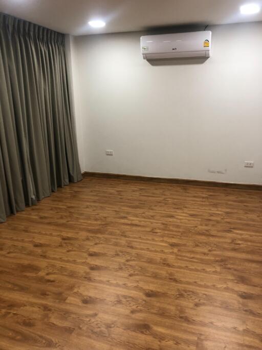 Empty living room with wooden floor and air conditioner