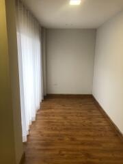 Empty room with wooden floor and white curtains