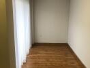 Empty room with wooden floor and white curtains