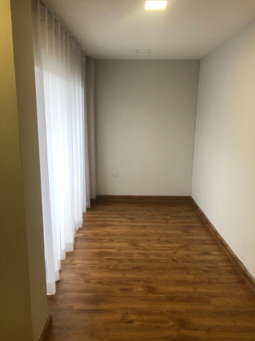 Empty room with wooden floor and white curtains